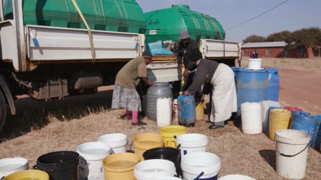 Menschen-in-Afrika-sammeln-Wasser-in-Behältern-aus-Tankfahrzeugen-Wasser-aufgrund-der-schweren-Dürre-in-Südafrika