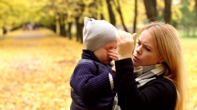 Mutter-beruhigt-ihren-Sohn-weint-im-Herbst-Park.