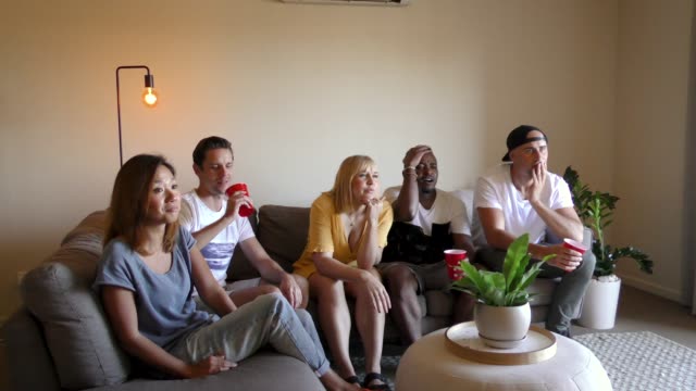 Group-of-young-multinational-adults-watching-TV.