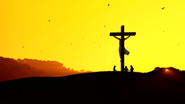 Jesus-on-cross-and-worshipers-praying-against-hot-sunset