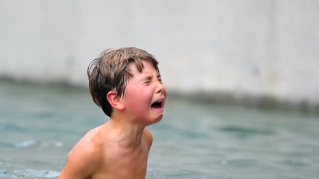 Child-in-agony-after-having-been-physically-hurt-at-the-pool.-Young-boy-cries-uncontrollably.-Child-crying-in-real-pain.