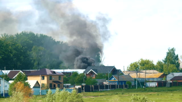Black-smoke-poured-behind-houses-in-the-village