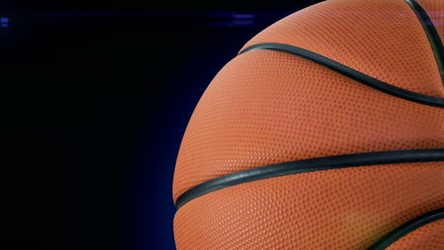 Bola-de-baloncesto-hermoso-primer-plano-a-cámara-lenta-en-negro-con-destellos-de-foto-de-rotación.-Bucle-de-baloncesto-3d-animación-de-giro-bola.-4-k-Ultra-HD-3840-x-2160.
