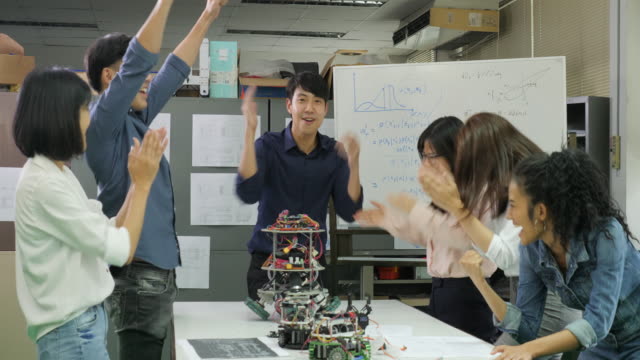 Group-of-successful-creative-engineers-celebrating-with-their-success.-Electronics-engineers-team-rejoicing-success.