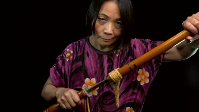 Slow-Motion-alte-asiatische-Frau-Vintage-Schwert-aus-der-Scheide-ziehen