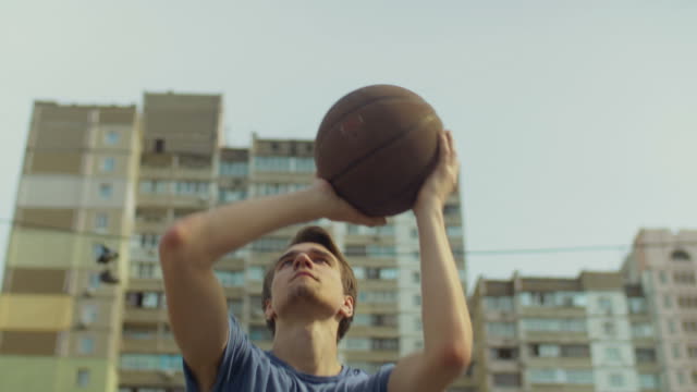 Outdoor-portrait-of-streetball-player-taking-shot