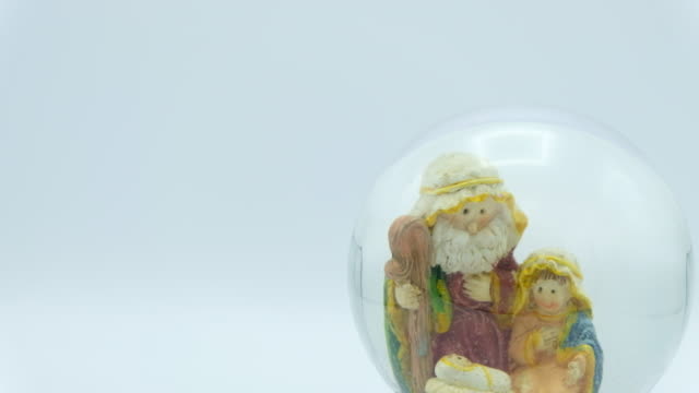 Christmas-nativity-scene-inside-glass-ball-on-white-background.-Left-copy-space.