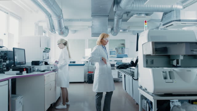 Team-of-Research-Scientists-Working-On-Computer,-with-Medical-Equipment,-Analyzing-Blood-and-Genetic-Material-Samples-with-Special-Machines-in-the-Modern-Laboratory.