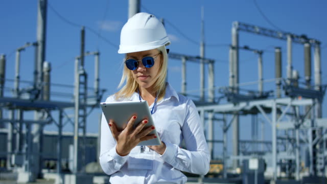 Smiling-female-electrical-worker-on-a-tablet