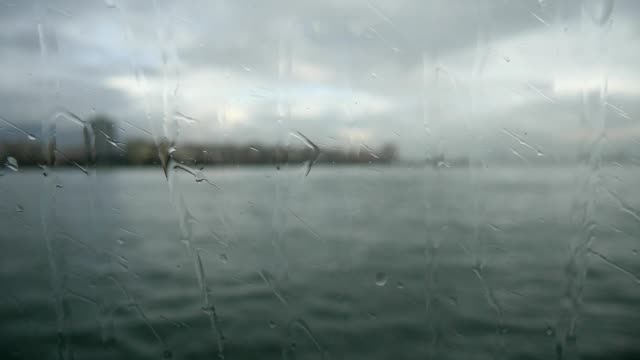 Blick-auf-das-Meer-und-den-Golf-durch-das-Fenster-mit-Regentropfen-auf-transparentem-Glas-von-der-Fähre.
