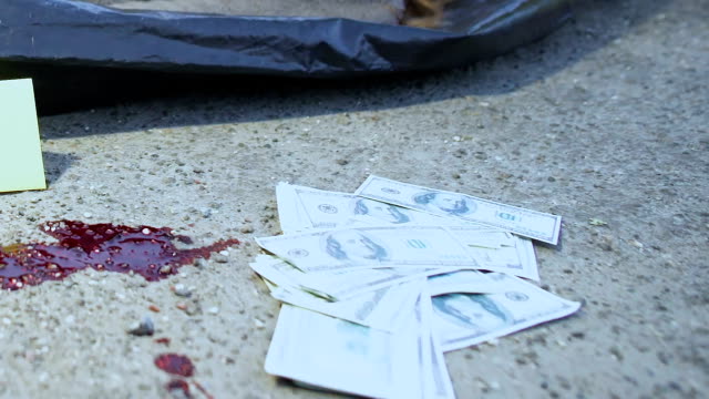 Cadáver-humano-sangre-y-dinero-en-asfalto,-robo-con-asesinato,-la-escena-del-crimen