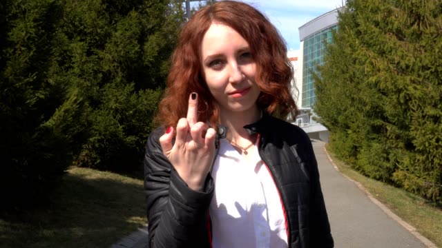 Outdoor-lifestyle-close-up-of-a-white-sexy-redhead-lady-show-middle-finger