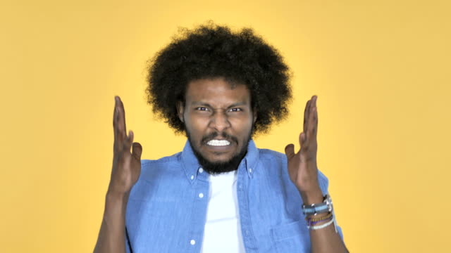 Schreien-wütenden-afro-amerikanischer-Mann-auf-gelbem-Hintergrund