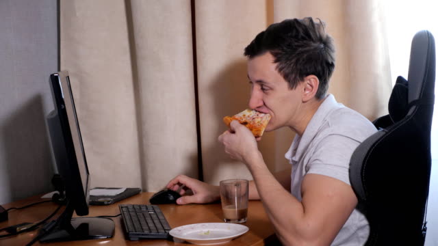 Hombre-en-su-casa-comiendo-pizza-y-jugar-en-la-computadora