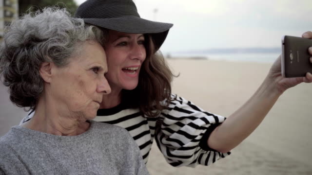 Erwachsene-Tochter-verzog-das-Gesicht-und-Selfie-mit-senior-Mutter