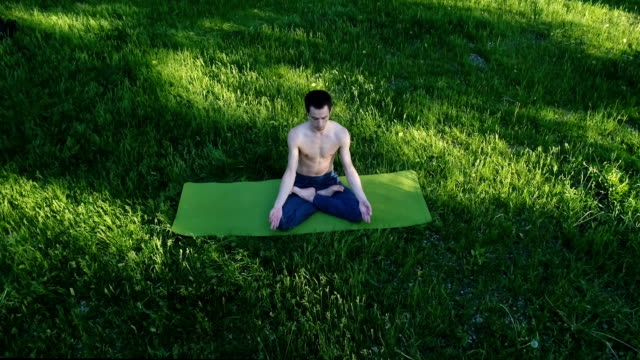 Professionelle-Yoga-Kerl-praktizieren-Yoga-im-Park.