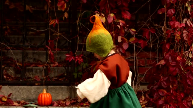 Lustiges-kleines-Mädchen-in-einem-Gnome-Kostüm-wirbelt-und-schaut-ihr-Kostüm