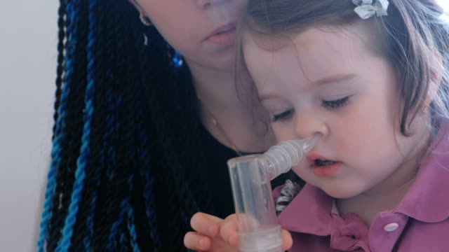 Kleine-süße-Mädchen-mit-ihrer-Mutter-durch-Inhalator-Maske-einatmen.-Verwenden-Sie-Vernebler-und-Inhalator-für-die-Behandlung.