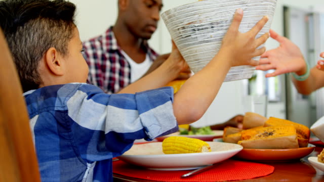 Familia-Black-tener-comida-en-la-mesa-de-comedor-en-hogar-4k
