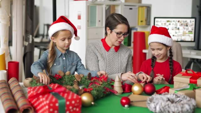 Girls-Making-Christmas-Decorations-with-Help-of-Female-Designer