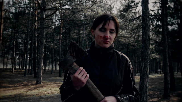 Beängstigende-Frau-Zombie-mit-Axt-geht-und-spuckt-Blut-nach-dem-Essen-von-Opfern-in-den-Wäldern