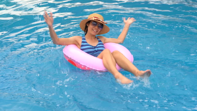 Chica-jugando-y-nadando-en-el-anillo-de-goma-flotando-en-la-piscina