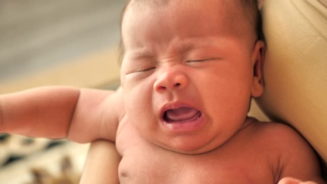 Sweet-crying-newborn-baby-at-mother-on-hands
