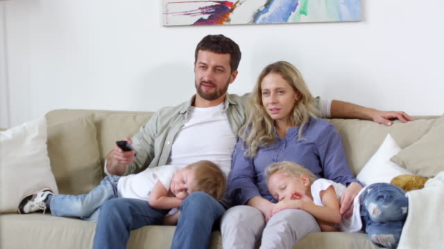 Couple-with-Sleepy-Children-Watching-TV