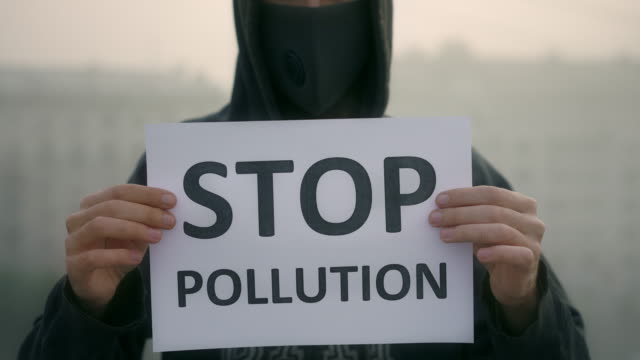 Protesta-en-máscara-de-aliento-soporte-fondo-de-niebla-de-la-ciudad-con-mensaje-detener-la-contaminación-4K