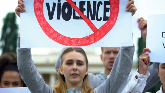 Crowd-with-posters-chanting-Stop-violence-slogans,-domestic-abuse,-human-rights