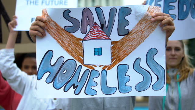 Activists-with-Save-homeless-poster-chanting-to-support-migrants,-refugee-rights