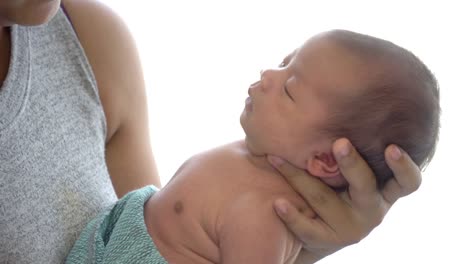 4K-Mittlere-Nahaufnahme-der-jungen-erwachsenen-asiatischen-Frau-Mutter,-die-in-der-Nähe-des-Fensters-im-Schlafzimmer-zu-Hause-steht-und-ihr-schlafendes-neugeborenes-Mädchen-Tochter-in-ihren-Händen-trägt.-Muttertag-und-Baby-Gesundheitskonzept.