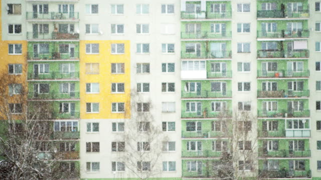 4K-Snow-falling-slowly-on-background-of-multicolored-building.