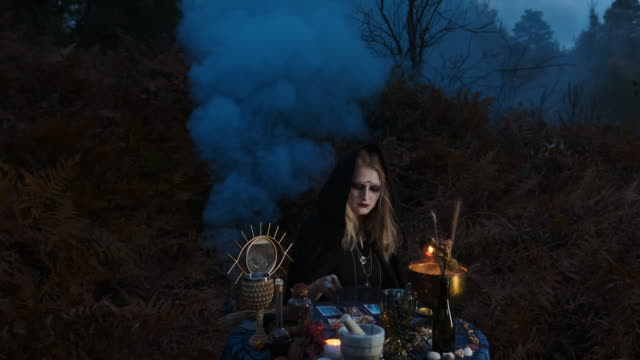 Halloween.-Young-Witch-Spells-At-The-Table.
