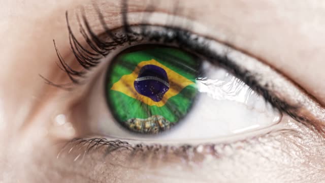 Frau-grünes-Auge-in-Nahaufnahme-mit-der-Flagge-von-Brasilien-in-Iris-mit-Windbewegung.-Videokonzept