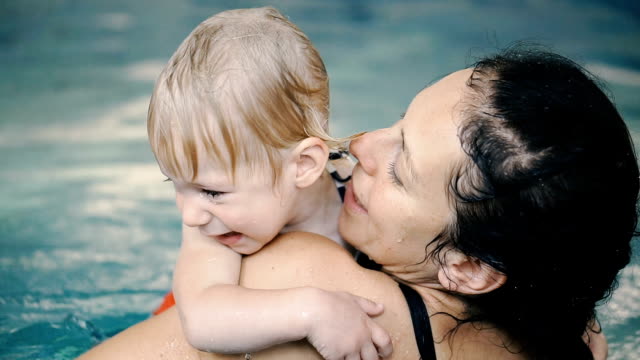 Schwimmbad.-Mama-bringt-einem-kleinen-Kind-das-Schwimmen-im-Pool-bei.