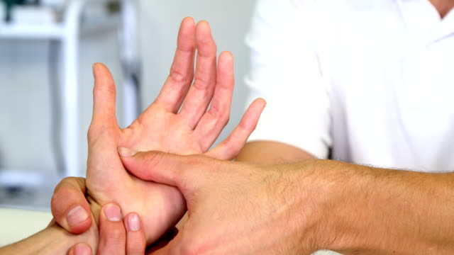 Physiotherapeuten,-die-eine-Frau-Handmassage-verleihen