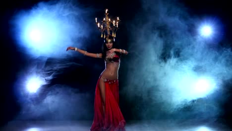 Attractive-belly-dancer-continue-dancing-with-candles-on-her-head,-black,-smoke
