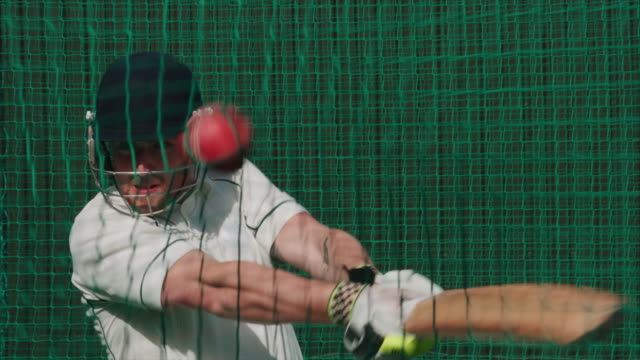 Ein-Cricket-Batsman-schlägt-den-Cricketball-üben-in-den-Netzen.