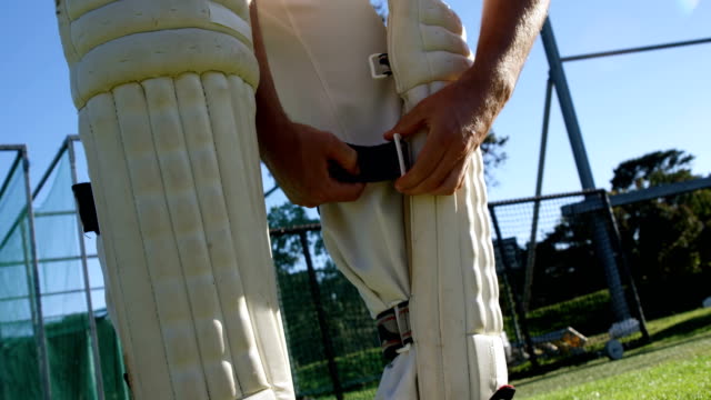 Cricketspieler-binden-seine-Watte-Pads-während-einer-Übung