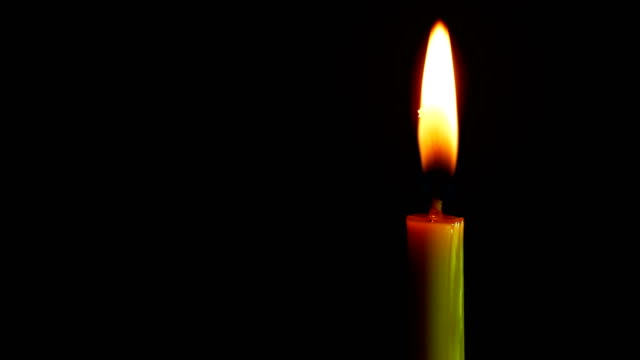 Close-up-candle-is-burning-on-black-background.
