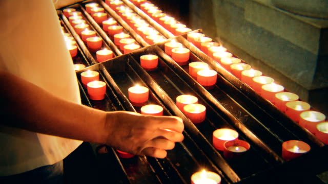 Frau-legt-eine-Kerze-am-Altar-in-der-Kirche.