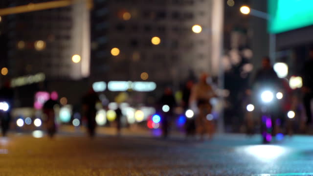 Lot-of-cyclists-ride-during-night-cycling-bike,-bicycle-parade-in-blur-by-illuminated-night-city-street.-Crowd-of-people-on-bike.-Bike-traffic.-Concept-sport-healthy-lifestyle.-Bright-shining-lights.-Low-angle-view