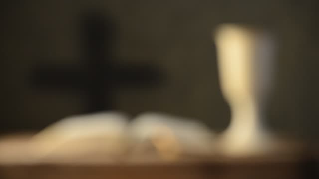 open-bible-with-chalice-and-cross,-shallow-depth-of-field,rack-focus