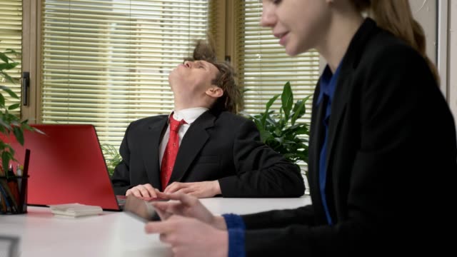 A-young-guy-in-a-suit-flirts-with-a-girl-in-the-office,-howls-like-a-wolf,-humor-concept.-Working-in-the-office-60-fps