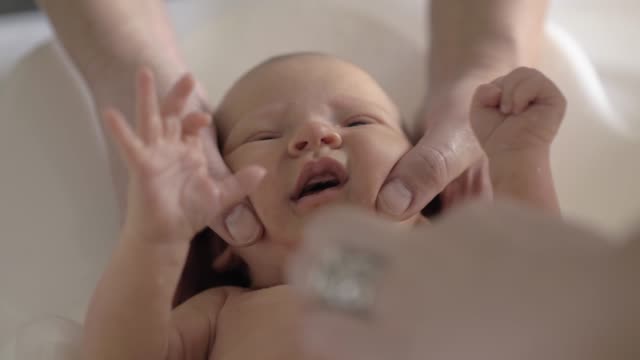 Neugeborenes-Baby-weint-beim-Baden