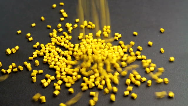 Plastic-pellets-crumbles-to-the-table-.-Plastic-raw-materials-in-granules-for-industry.-Polymer-resin.