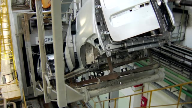 car-bodies-are-moving-over-conveyor-tape-in-a-workshop-of-car-factory