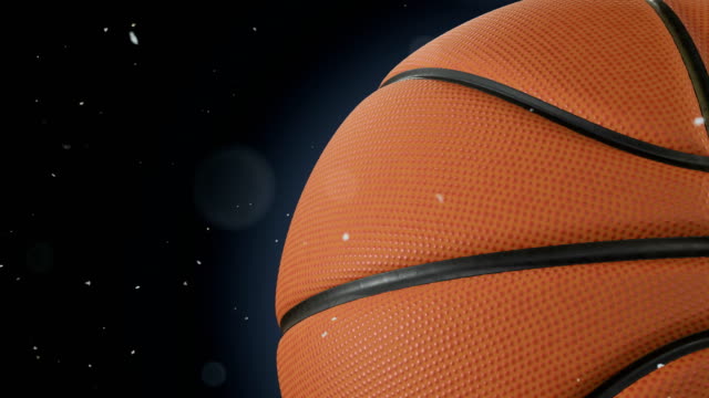 Bola-de-baloncesto-hermoso-primer-plano-a-cámara-lenta-en-negro-con-partículas-de-polvo-del-vuelo-de-rotación.-Bucle-de-baloncesto-3d-animación-de-giro-bola.-4k-UHD-3840-x-2160.