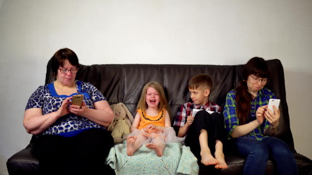 La-familia-se-sienta-en-el-sofá-y-utiliza-gadgets-digitales.